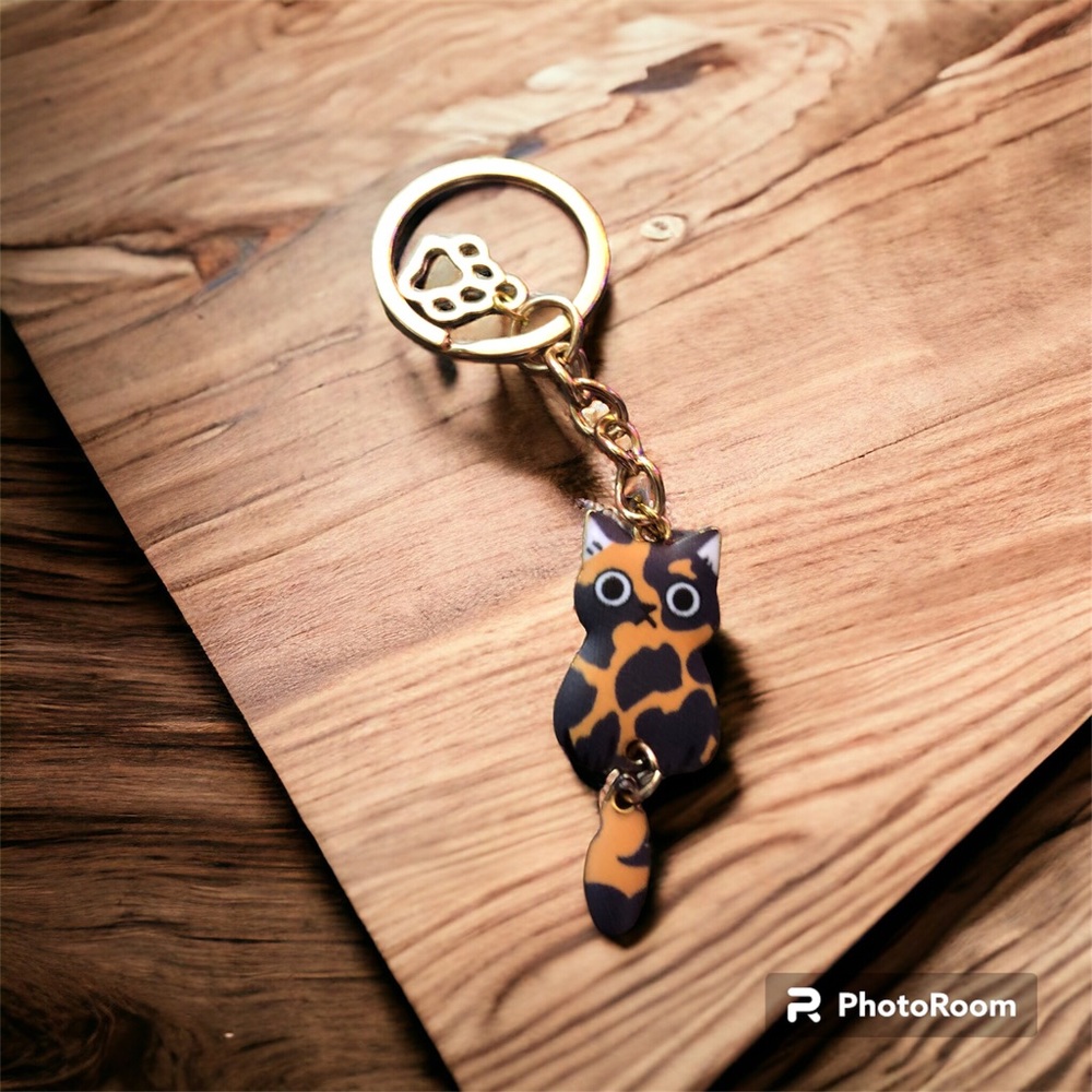 Cat charm.  Orange & black with frown.